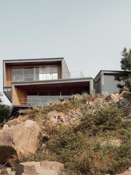 (Duplicate of 57) The Lakehouse appears to grow out of the rocky landscape, its cantilevered forms creating sheltered outdoor spaces with breathtaking views.