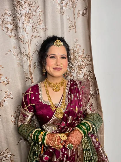 A beautiful Marwari bride embracing a traditional Marathi look for her engagement, complete with green bangles and gold jewelry.