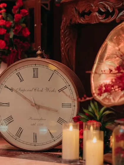 Detail shot of the vintage decor, including an old-fashioned clock and a gramophone filled with flowers.