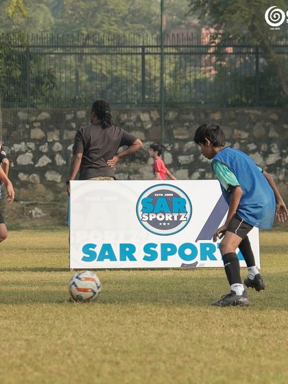 A player prepares to take control of the ball near the Sar Sportz branding board.