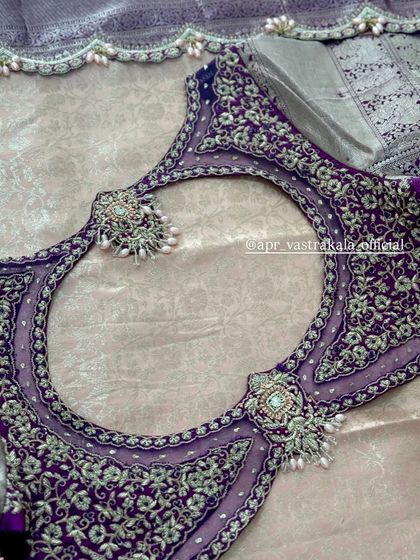 A purple blouse with a sheer back and intricate floral embroidery.