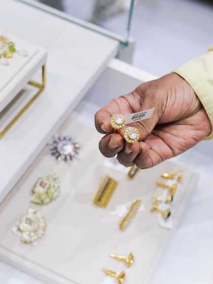 A guest at our Hyderabad store holds up a pair of classic Kundan studs, considering them for her collection.