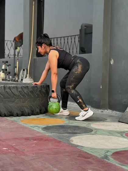 Here I am performing a kettlebell lift, a core exercise for building functional strength. My coaching programs incorporate strength training to help you lose fat, build muscle, and improve your overall fitness.