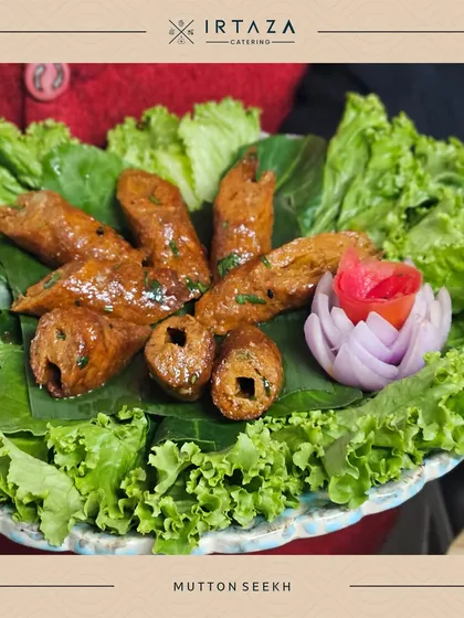 Mutton Seekh Kebabs, beautifully arranged on a bed of lettuce with a carved tomato and onion garnish. The presentation highlights the care I put into every single dish.
