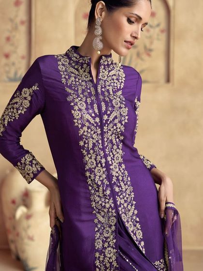 Feel like royalty in this violet premium silk palazzo suit. The intricate thread embroidery on the jacket-style top gives it a majestic look, perfect for a wedding or formal event.