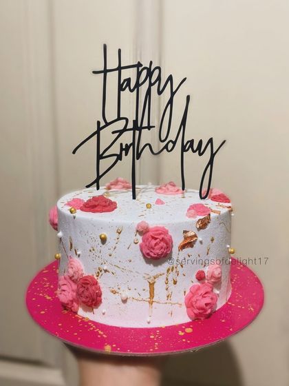 A simple birthday cake with pretty little pink flowers and a touch of gold splatter. This design is perfect for someone who loves understated elegance.