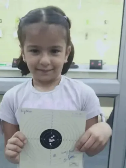 Our little star, all smiles after a good shooting session. We focus on making the sport enjoyable for our youngest members while teaching them discipline.