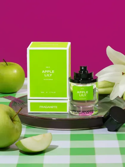 A vibrant shot of 'Apple Lily' perfume with a picnic-themed setup. The bright colors and fresh ingredients make the fragrance feel fun and youthful.