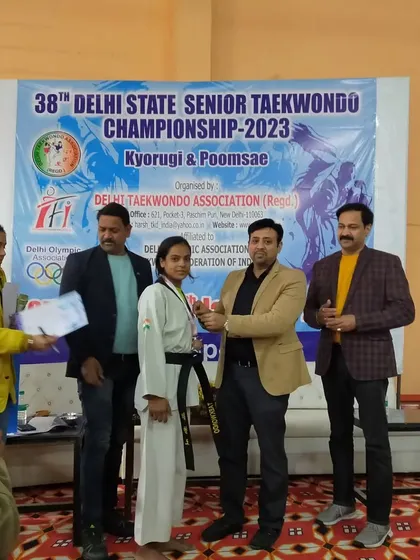 Komal receiving her certificate and medal at the state championship.