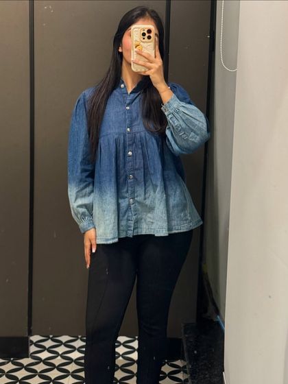 A denim peplum top paired with black trousers for a smart-casual office look. I love finding unique pieces like this to elevate your everyday work style.