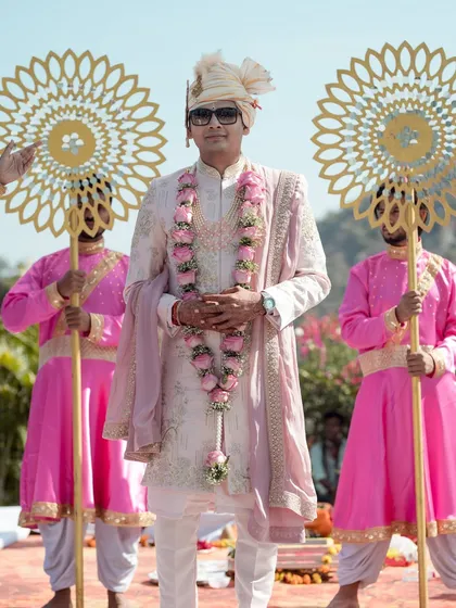 The groom's hero moment. A classic and stylish entry, flanked by attendants with traditional props, looking every bit the part of a modern-day prince.