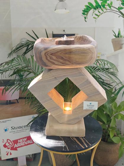 This unique piece combines a tabletop fountain with a lamp. Carved from Rainbow Sandstone, it features a geometric base with a cutout for a tea light, adding a warm glow to the gentle water flow.