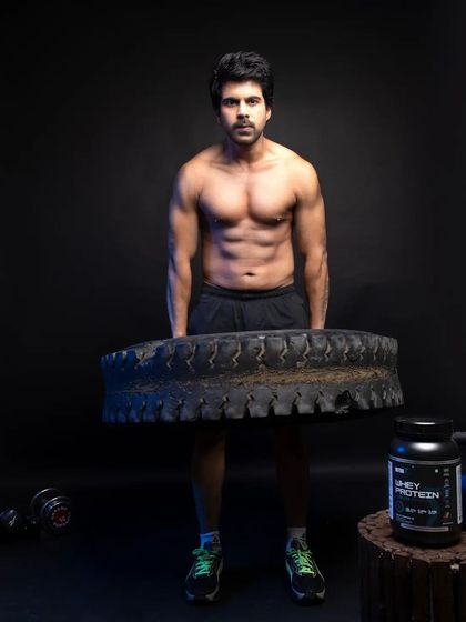 A powerful shot of the male model lifting a heavy tire, with the whey protein product displayed next to him. This image communicates raw strength and endurance, creating a strong aspirational message for the brand.