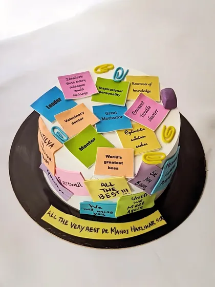A truly personal farewell cake for a beloved boss. The entire cake is covered in edible sticky notes, each featuring a heartfelt message or inside joke from the team, like "Great Motivator" and "Eminent trouble shooter." It’s a sweet and memorable way to say goodbye.