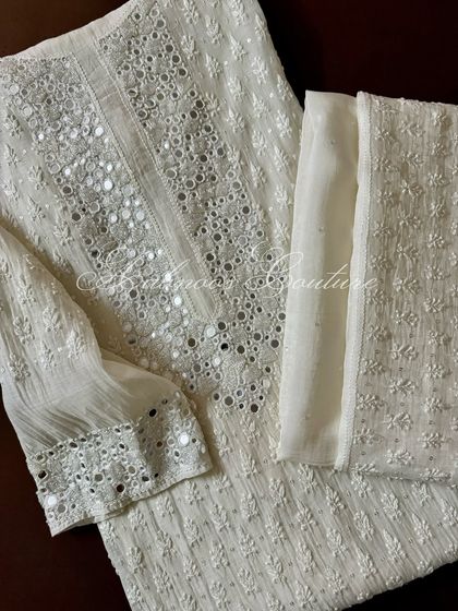 This off-white Chikankari suit is thoughtfully accentuated with fine mirrorwork, adding a touch of refined glamour and texture to the traditional embroidery.