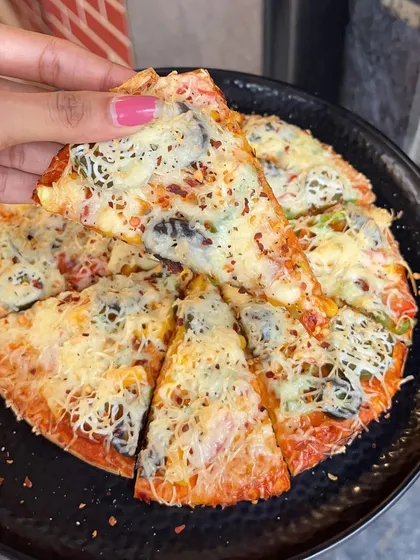 A slice of my All Veg Pizza, showing the crispy crust, fresh vegetables, and melted cheese.