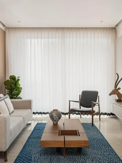 The living room of Apartment 3201 is a study in calm, minimalist design. We used a neutral color palette, clean-lined furniture, and a textured blue rug to create a serene and sophisticated space, with warm wood panels adding a touch of natural elegance.