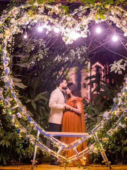 A romantic silhouette of an expecting couple within the heart-shaped light prop, a beautiful way to announce a new beginning.