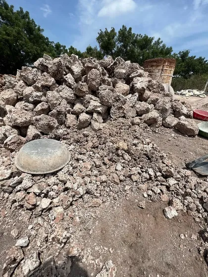 A pile of limestone chunks before being fired in the kiln. This is the raw material, straight from the earth, that will become the breathable plaster on our walls.