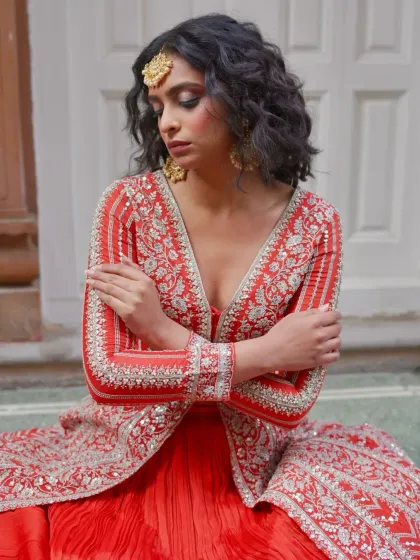 A moment of quiet beauty in a striking red embroidered jacket gown. This outfit is for the bride who is confident, bold, and unapologetically herself.