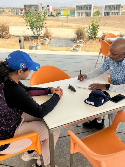 A one-on-one mentoring session at the clubhouse. Coaching extends beyond the driving range; it's about guiding the player's entire journey.
