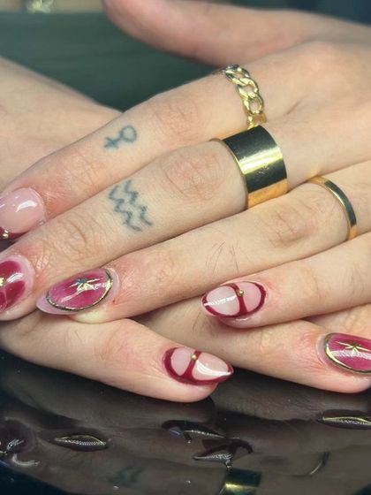 A beautiful and artistic design with a sheer red watercolor effect, gold outlines, and starburst charms.