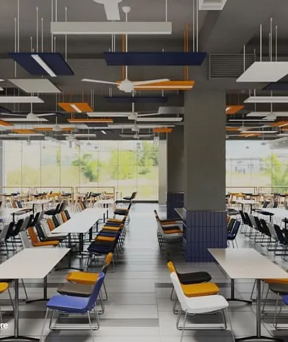 The hostel cafeteria at Amity University, Bangalore, designed with colorful chairs and suspended acoustic panels. The layout offers a vibrant and energetic atmosphere for students to socialize and dine.