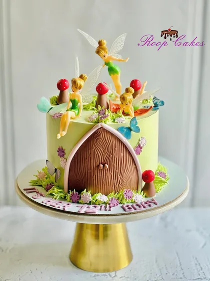 Sprinkling a little magic with this enchanting fairy cake, complete with a fairy door and multiple tiny fairy figurines.
