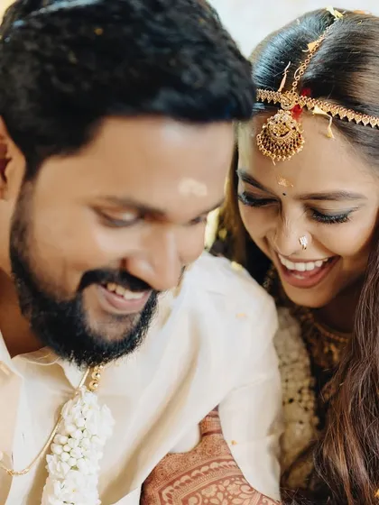 Laughter and joy are the best accessories. This candid shot captures a happy moment between the couple, with the bride's makeup looking flawless and radiant.