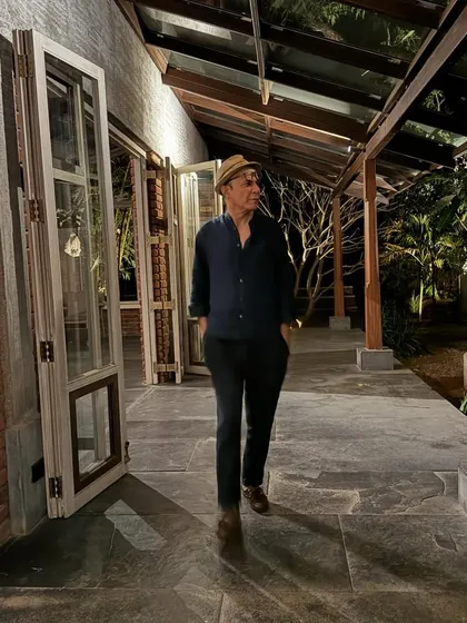 A quiet evening walk along the verandah of The Shell. The space is designed to feel both open and sheltered, blurring the line between a building and a garden path.