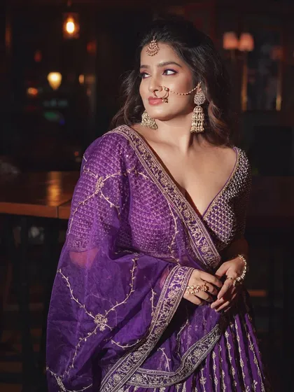 A soft and elegant pose. The makeup looks beautiful in the warm, ambient lighting of the venue.