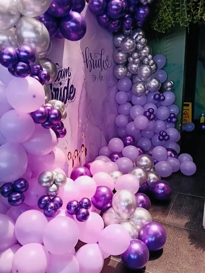 A closer look at the cascading balloon arrangement for the bridal shower. I love mixing different shades and sizes of balloons, like these lilac, purple, and chrome ones, to create depth and a sense of abundance.