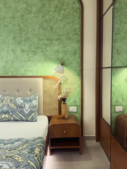 Another view of the pastel green and wood bedroom, highlighting the mirrored wardrobe which makes the room feel more spacious and bright.