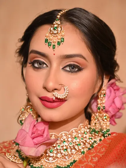 A portrait of the model with a lotus flower, showcasing the bold pink lip and winged eyeliner.