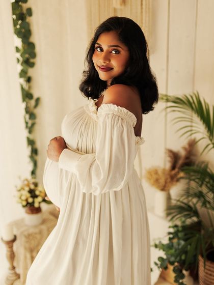 A simple and sweet portrait in a white flowing dress, capturing the quiet anticipation of meeting her little one.