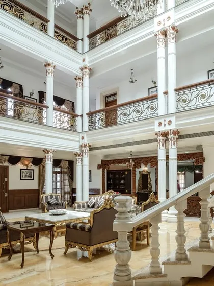 This angle highlights the interplay between the ground floor living space and the overlooking corridors on the upper levels, connected by the grand white columns.