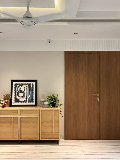 This shot shows how we can completely change a space without structural work. We hid the door with seamless paneling and upcycled the existing credenza to create a clean, warm, and modern entryway.
