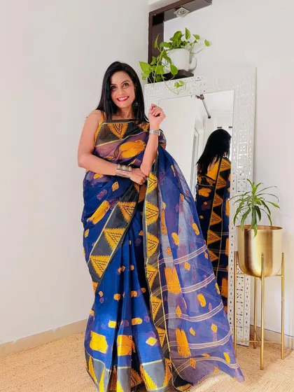 A deep blue Tant saree with a unique yellow geometric print. This is a modern take on a traditional saree, perfect for someone who loves bold designs.