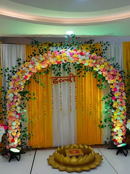 The Haldi stage illuminated with spotlights, making the colors pop and creating a festive ambiance.