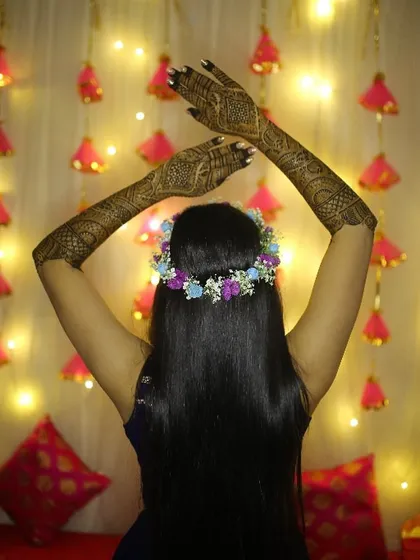 A beautiful back shot showing the floral hair accessory and the full length of the bride's Mehendi design.