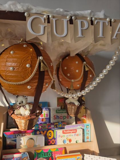 A detailed shot of the handcrafted hot air balloons and the curated selection of children's books, ready to start a new library.