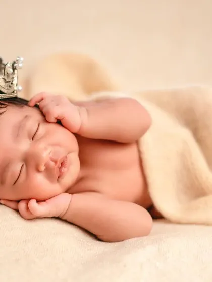 A beautiful, classic pose on a cream-colored blanket. The tiny crown adds just a touch of royalty to this otherwise simple and timeless portrait.