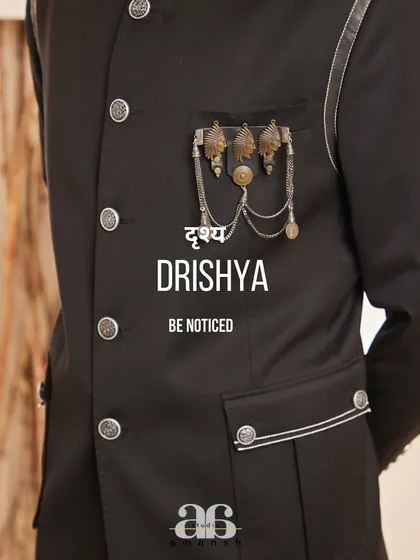 "Be Noticed." This image captures the essence of our brand, focusing on the unique metallic embellishment of our black bandhgala, a detail designed for the man who wants his style to speak for itself.