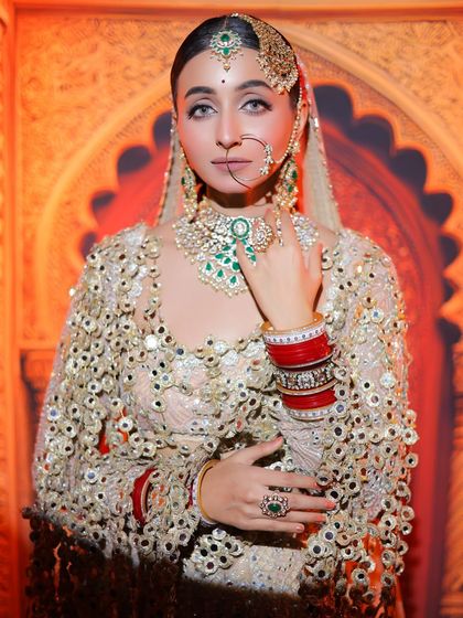 A portrait that captures the bride's confidence and grace. The emerald green jewellery adds a beautiful pop of colour against the ivory outfit.