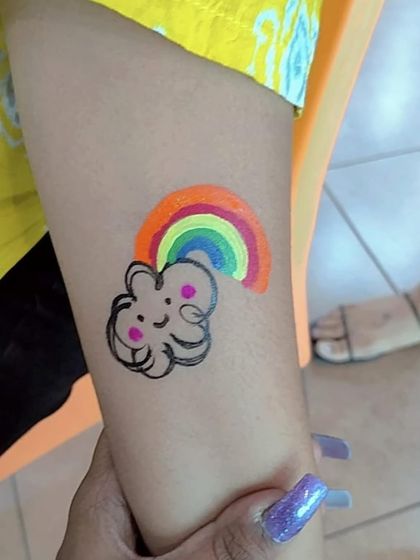 A happy little cloud and rainbow tattoo. These bright and cheerful designs are always a favorite at children's parties.
