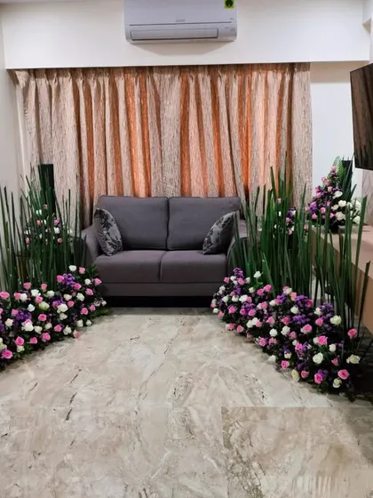 We also offer customized floral arrangements to enhance your home decor for any special occasion. This setup includes floor-level bouquets of pink and white roses, framed by tall green sticks for a modern look.