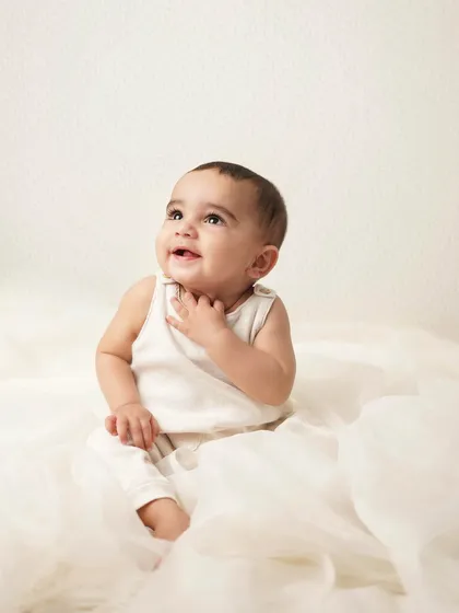 Looking up in wonder. The soft lighting and dreamy background create a beautiful, ethereal portrait of this baby boy.