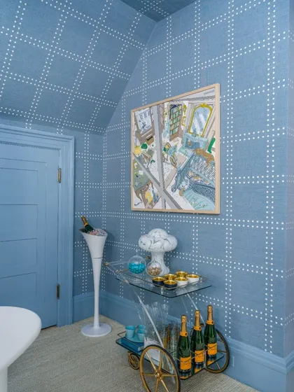 A playful yet sophisticated blue-on-blue dotted grid pattern envelops this room, covering even the ceiling. This design choice creates a cohesive and immersive environment, perfect for a chic bar or lounge area.