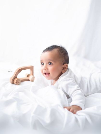 A simple and sweet half-birthday moment, capturing this baby's curiosity as he plays with a wooden toy car.