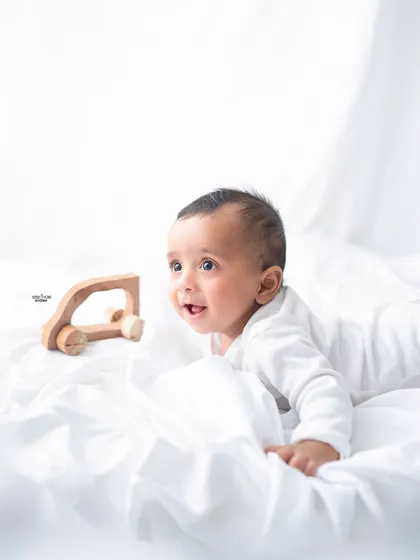 A simple and sweet half-birthday moment, capturing this baby's curiosity as he plays with a wooden toy car.